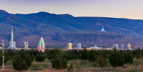 Wednesday, 26 June 2019; Ashgabat, Turkmenistan; Beautiful cityscape, panorama view on the white city at blue mountains with iconic landmarks of the capital of Central Asian state few minutes sunset.