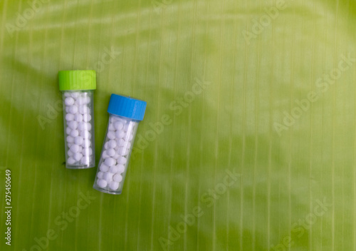 Natural Homeopathic treatment - Close view image of Homeopathic medicine bottle on banana leaf