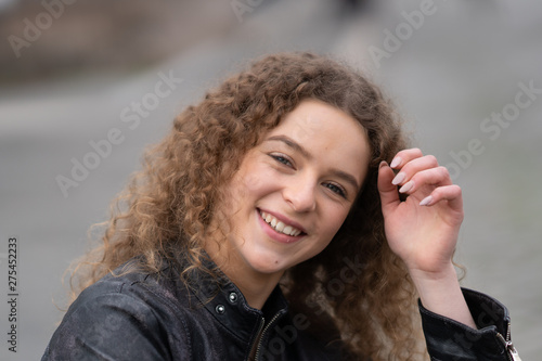 Cheerful and happy young woman looking at csamera and smiling