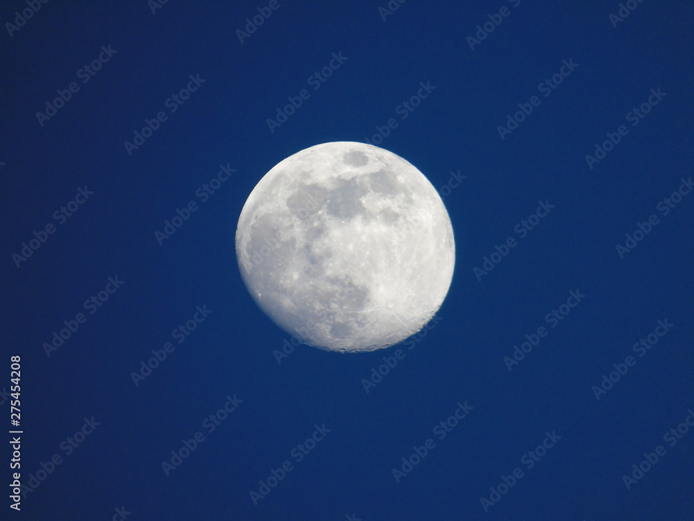 Genova, Italy - 06/15/2019: An amazing photography of the full moon over the city of Genova by night with a great clear and blue sky in the background and some stars. Genova, Italy - 06/15/2019: An amazing photography of the full moon over the city of Genova by night with a great clear and blue sky in the background and some stars.
