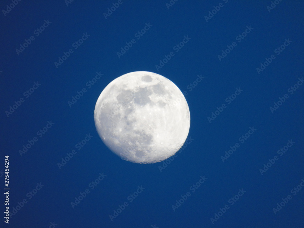 Genova, Italy - 06/15/2019: An amazing photography of the full moon over the city of Genova by night with a great clear and blue sky in the background and some stars. Genova, Italy - 06/15/2019: An amazing photography of the full moon over the city of Genova by night with a great clear and blue sky in the background and some stars.