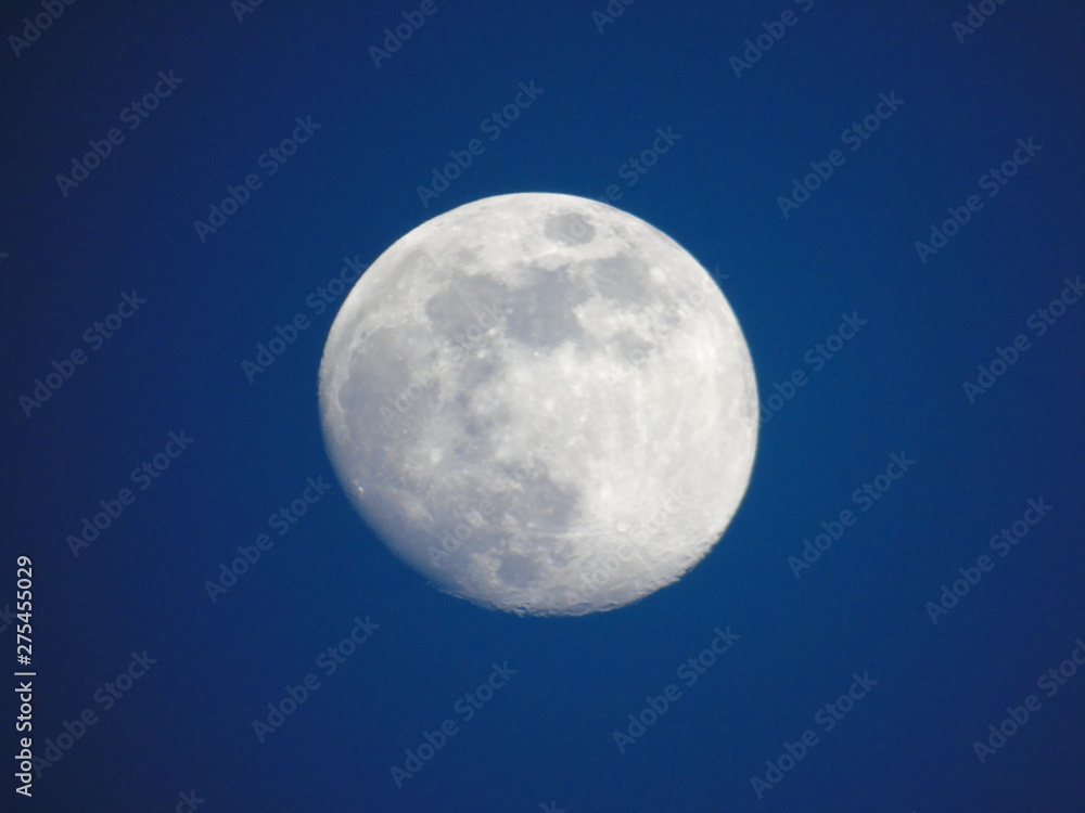 Genova, Italy - 06/15/2019: An amazing photography of the full moon over the city of Genova by night with a great clear and blue sky in the background and some stars. Genova, Italy - 06/15/2019: An amazing photography of the full moon over the city of Genova by night with a great clear and blue sky in the background and some stars.