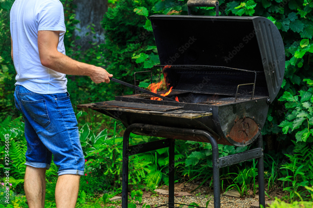 men in white t-shirt is preparing barbecue place fire men in white t-shirt is preparing barbecue place fire