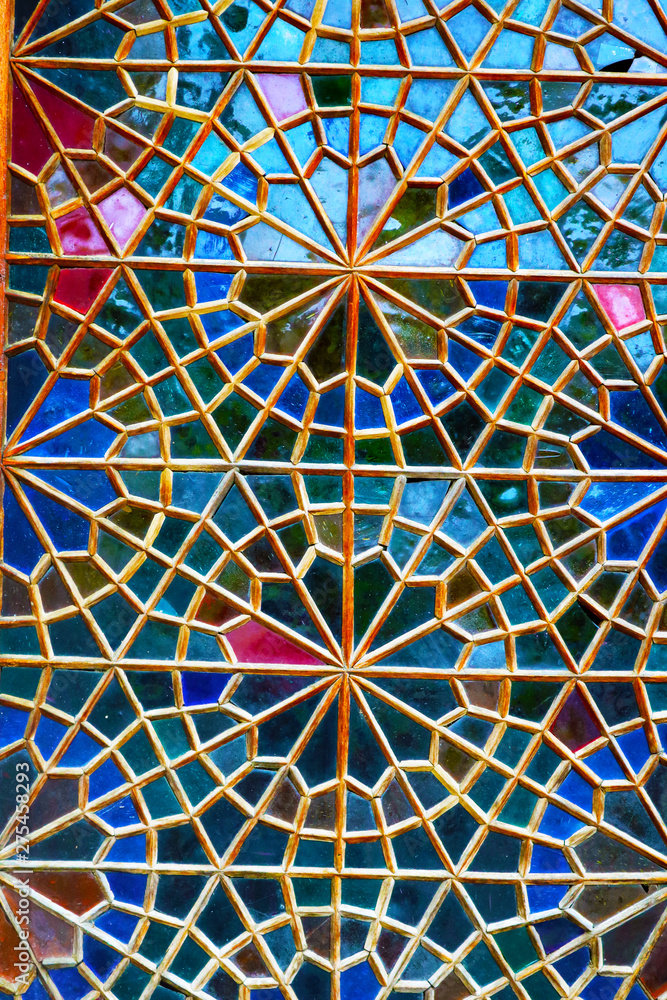 Traditional oriental window pattern made of little colorful glasses.  Detail of the stained glass window. A geometric pattern on the side of the Palace of Shaki Khans. Sheki, Azerbaijan.