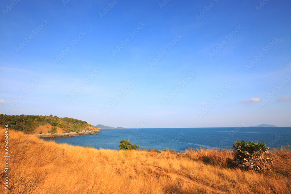 Beautiful seascape with sky twilight of sunset and sea horizon with Calm and blue sky.Dry grass field on mountain of Phrom Thep Cape is famous place in Phuket island, Thailand.