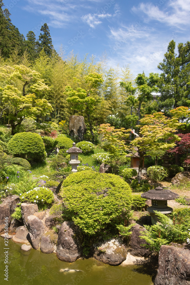 View on a beautiful green and blooming temple garden on a sunny day in Japan