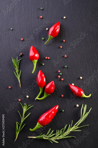 Chili peppers with rosemary on a black background