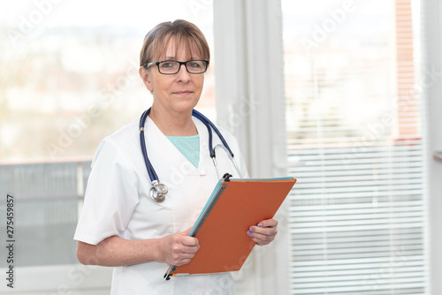 Portrait of doctor standing and holding a folder