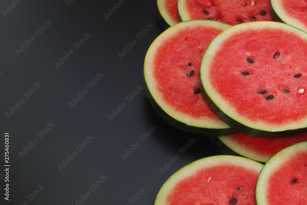 Watermelon slices on black table with copyspace