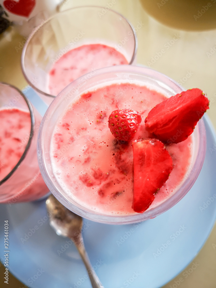 Strawberry jelly in a glass cup, chia seed pudding with strawberries, on a blue plate Strawberry jelly in a glass cup, chia seed pudding with strawberries, on a blue plate