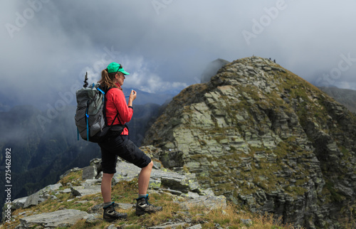 Female hiker on a narrow ridge in the mountains. Via Alta Verzasca, Switzerland.
