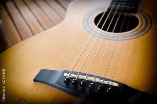 Acoustic guitar on a wooden background with copy space.The guitar is a fretted musical instrument that usually has six strings.