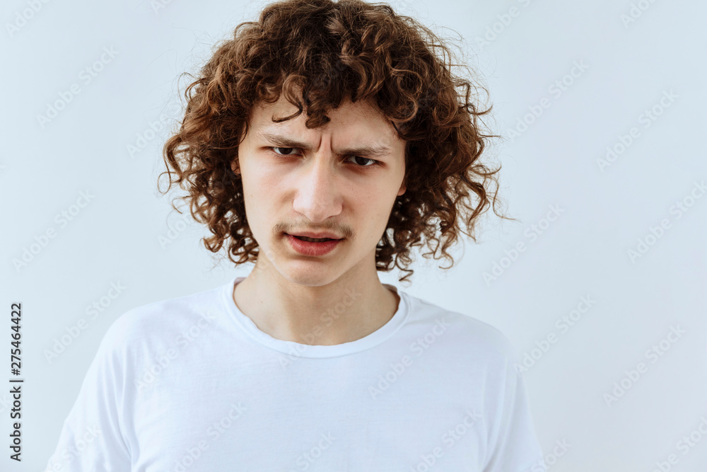 Frustrated and stress emotion. Portrait of Curly teen guy against white background Frustrated and stress emotion. Portrait of Curly teen guy against white background
