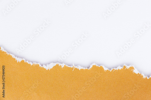 Torn edge of yellow paper on a white surface. Empty background.