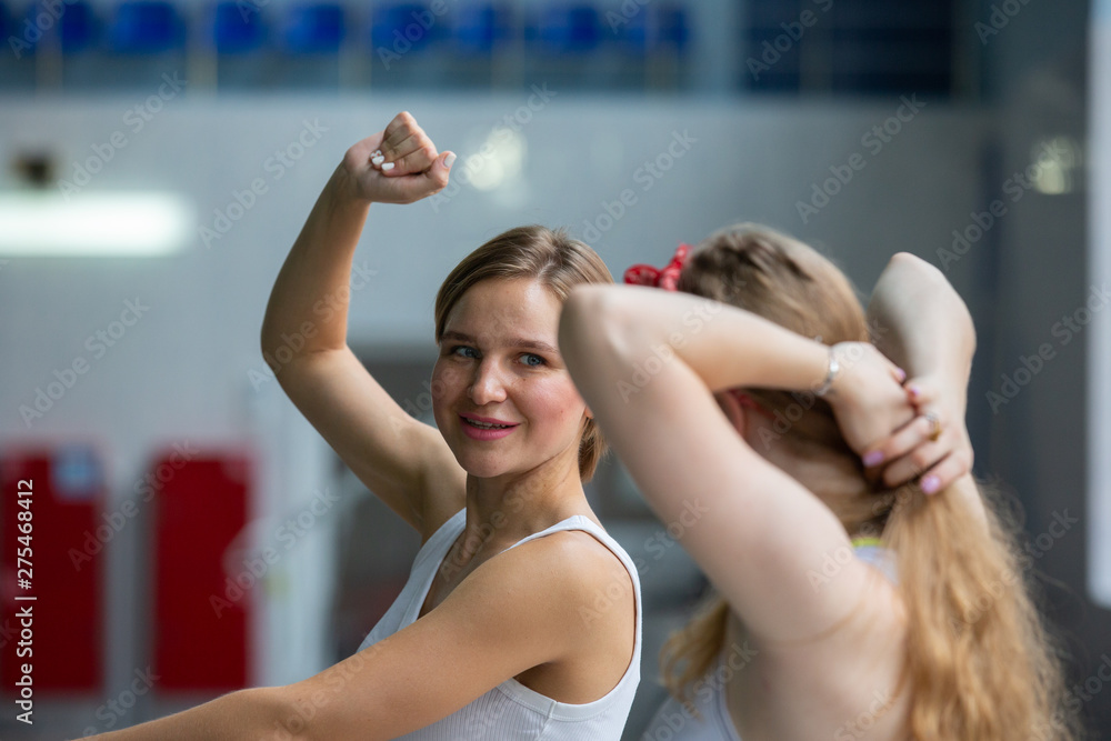 Fototapeta premium Pretty swimming coach smiling at camera at the leisure center
