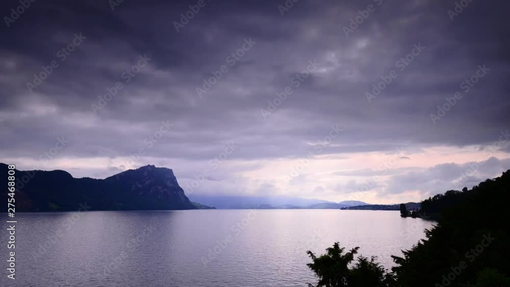 The grand play of light and shadows over the Alps mountains. Lake Lucerne. Switzerland. The bright sun after the storm rises because of the clouds The grand play of light and shadows over the Alps mountains. Lake Lucerne. Switzerland. The bright sun after the storm rises because of the clouds