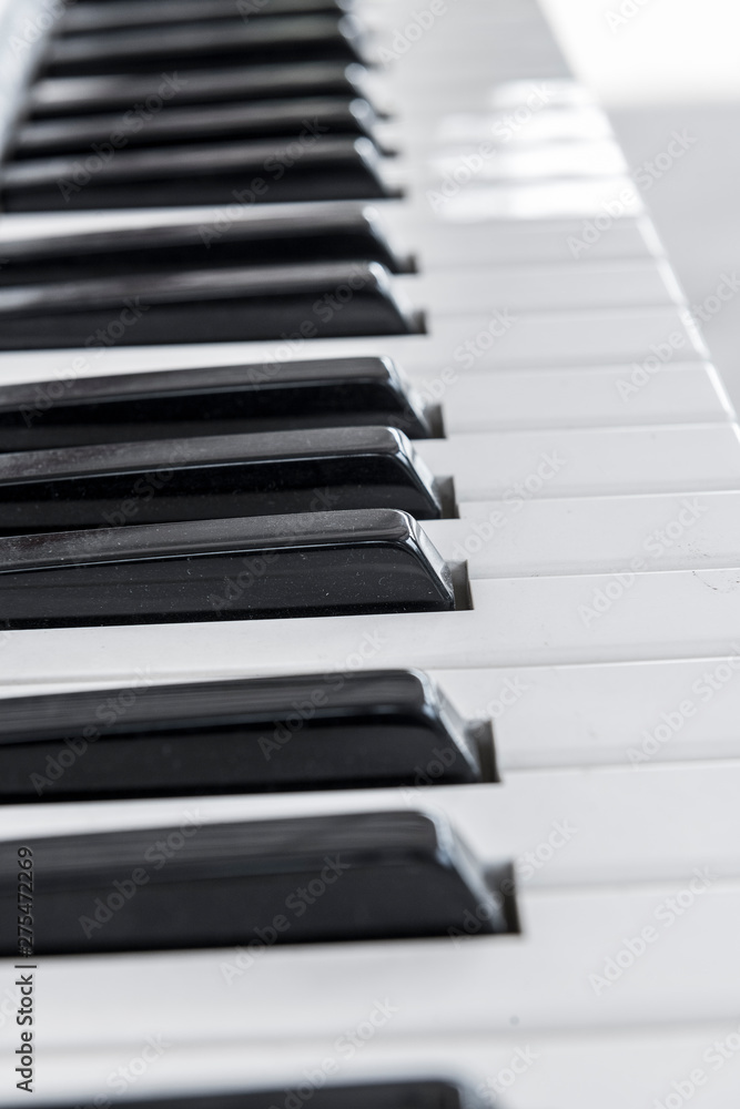grand piano keyboard with glossy black and white keys as a music background in wide panoramic banner format, selected focus, narrow depth of field grand piano keyboard with glossy black and white keys as a music background in wide panoramic banner format, selected focus, narrow depth of field