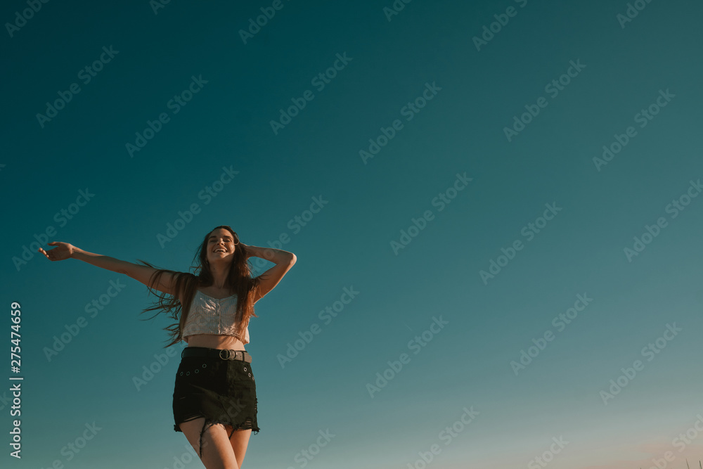 Obraz premium a young woman in a summer day with a blue sky - negative space