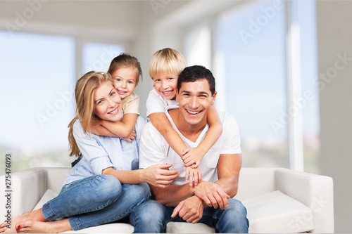 Beautiful smiling family sitting at sofa at home