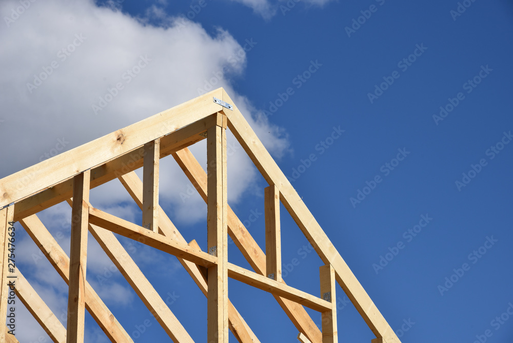 Wood frame residential building under construction.Building construction, wood framing structure at new property development site.new home currently under construction against blue sky.mortgage, loan.