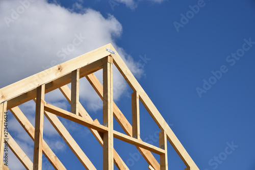 Wood frame residential building under construction.Building construction, wood framing structure at new property development site.new home currently under construction against blue sky.mortgage, loan.
