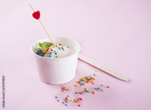 Vanilla ice cream with mint leaf, strawberries and blueberries on the pink background © zulfiska