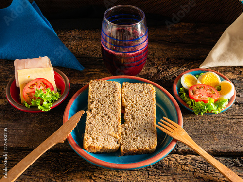 Homemade bread without gluten ready to prepare a sandwich with lechucha, cheese, ham and tomato. And, to drink, blueberry juice and chocolate, for breakfast