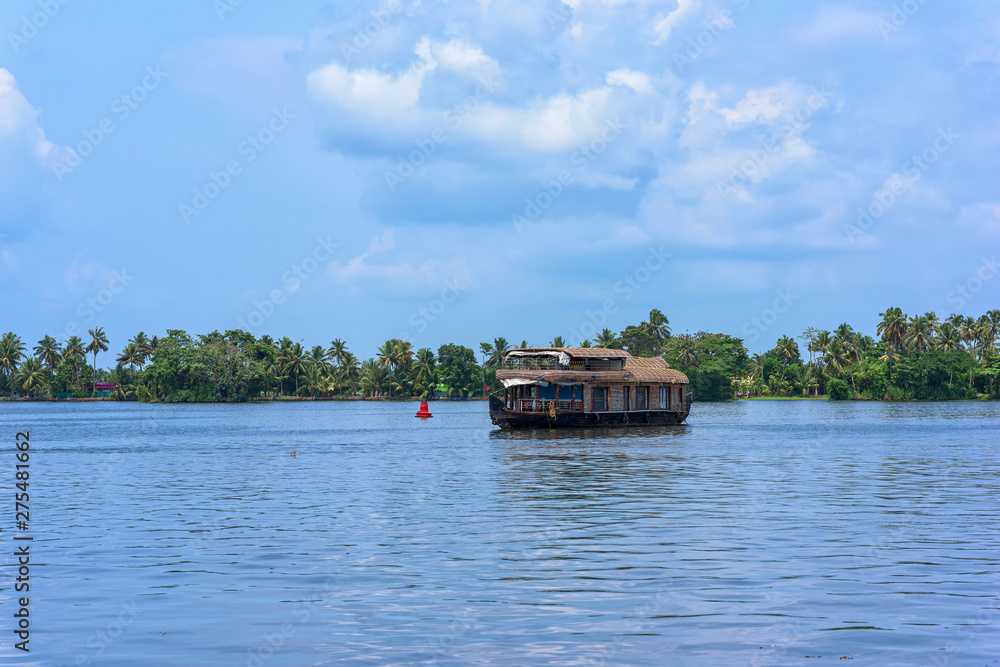 River view and traditional house boat in Kerala's Backwaters, India.