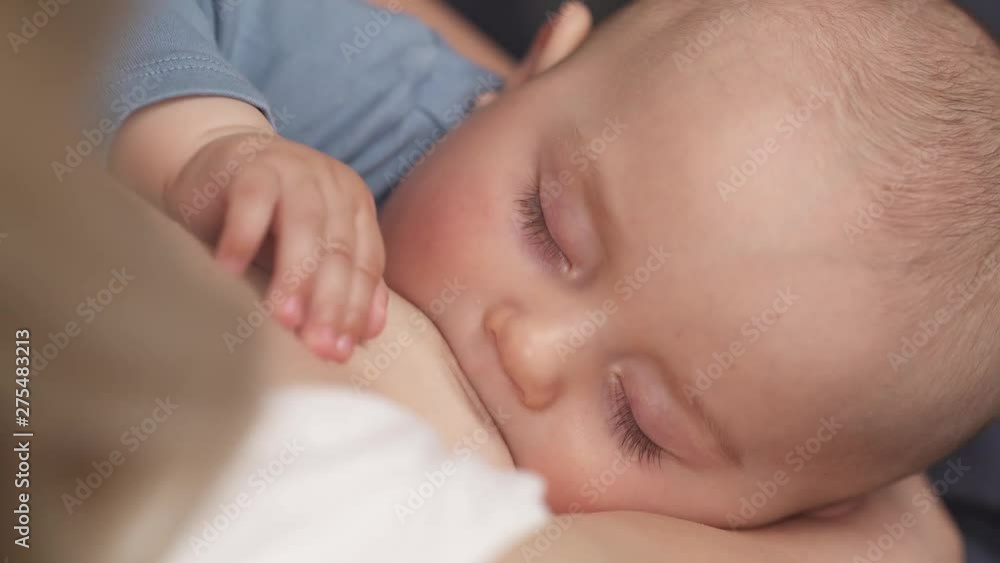 Closeup top view of young breastfeeding mother feeding her baby. Closeup top view of young breastfeeding mother feeding her baby.