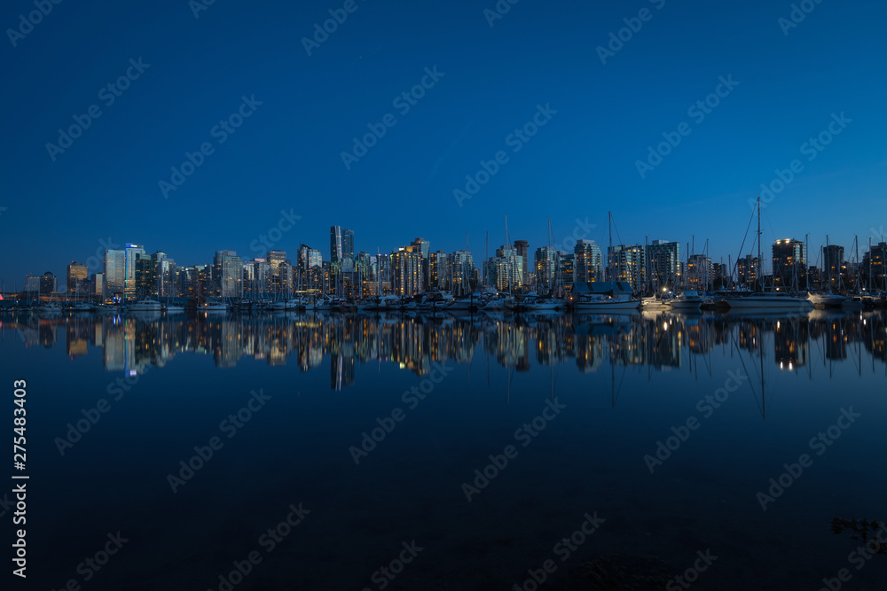 Skyline of Downtown Vancouver mirrored in Pacific Ocean.