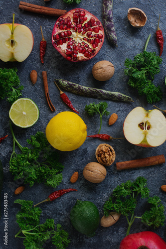 Raw organic fruit  green  vegetables and nuts on dark stone table