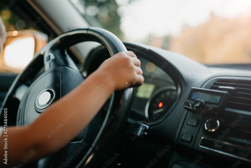 hands of a small child driving a car. driving instruction in childhood. hands of a small child driving a car. driving instruction in childhood.