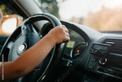 hands of a small child driving a car. driving instruction in childhood. © velimir