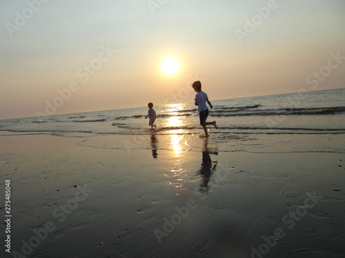 Zwei Kinder laufen am Strand im Wasser 1