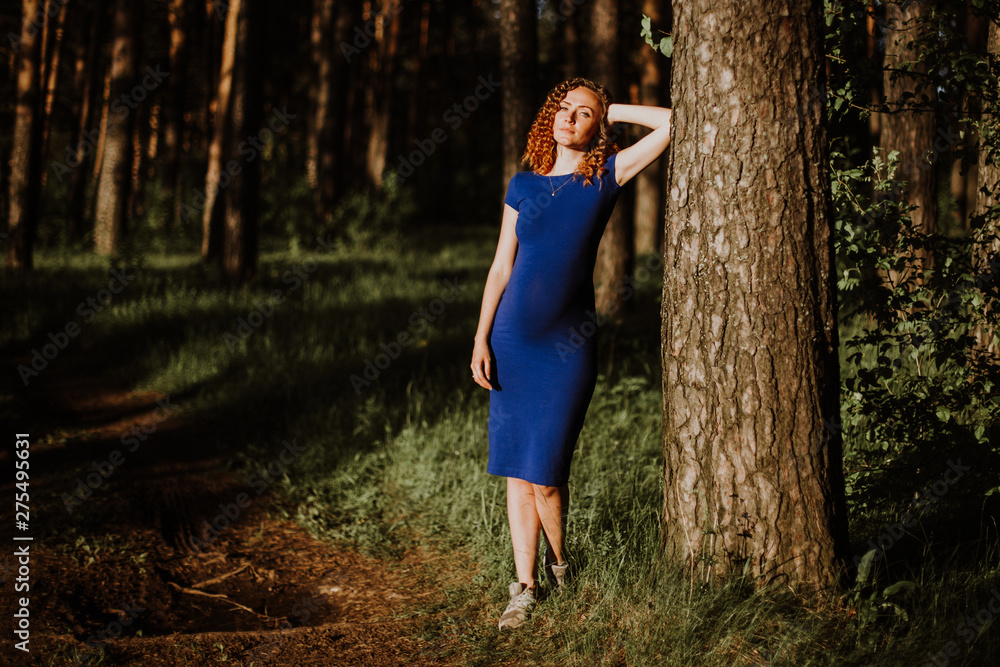 warm evening sun gently illuminates a beautiful girl walking through the woods warm evening sun gently illuminates a beautiful girl walking through the woods