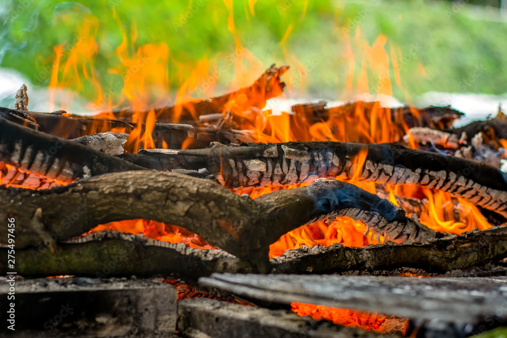 Charred wood and bright flames on dark background Charred wood and bright flames on dark background