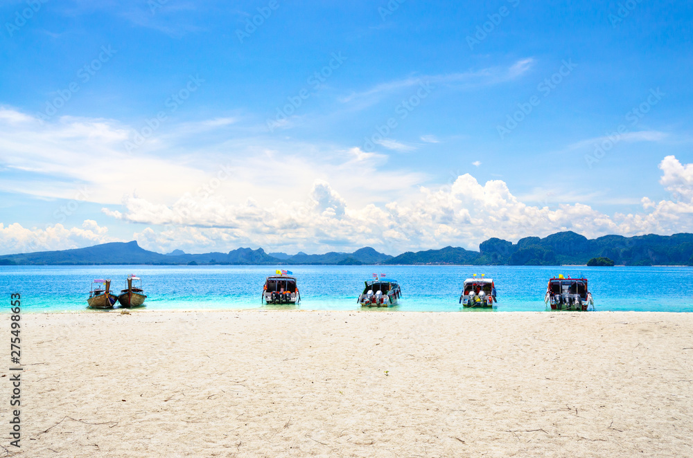 Tour boat to park on the beautiful beach With a backdrop of mountain views and Bright blue sky, Poda Island, Krabi, Thailand.