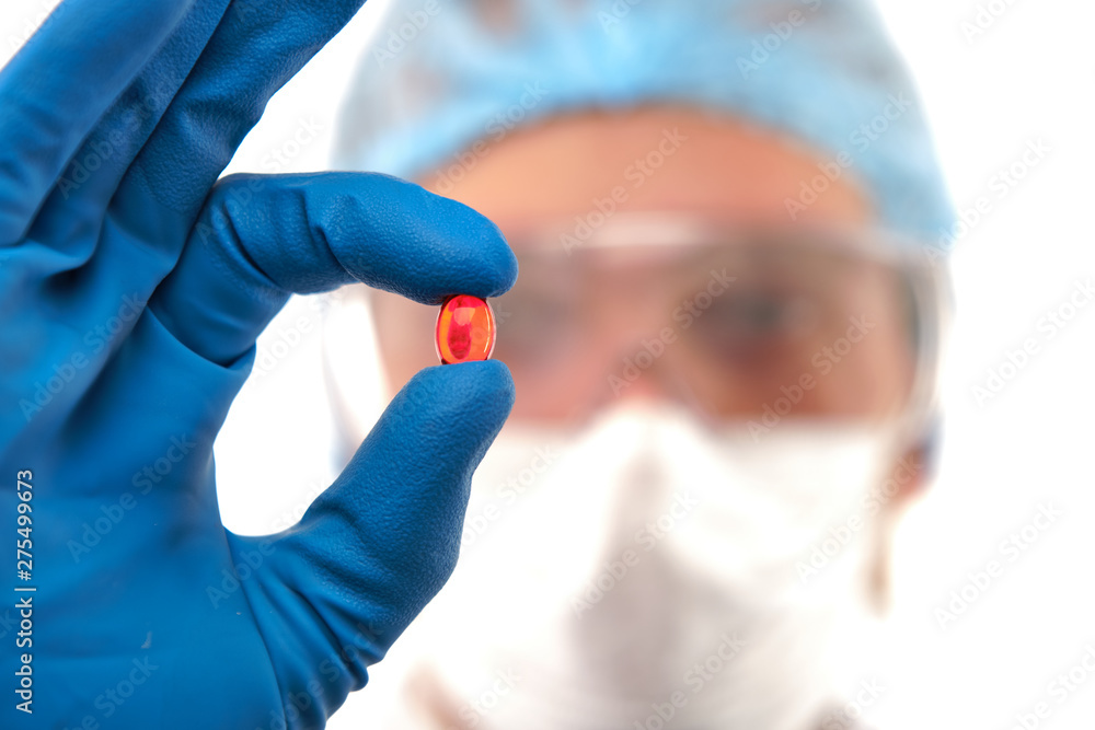 Pharmacist with single cure pill in hand Pharmacist with single cure pill in hand
