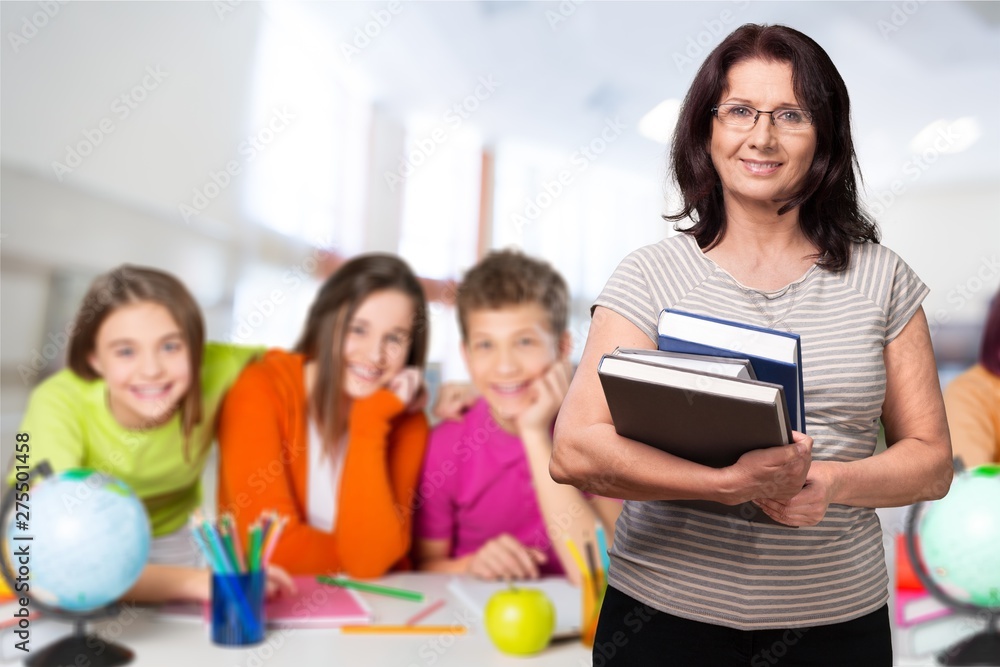 Young female teacher with students in classroom Young female teacher with students in classroom