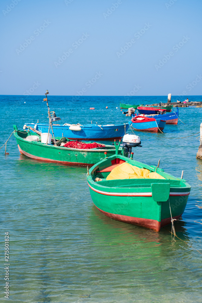 Beautiful old colored fishing wooden boats on the water, vertical