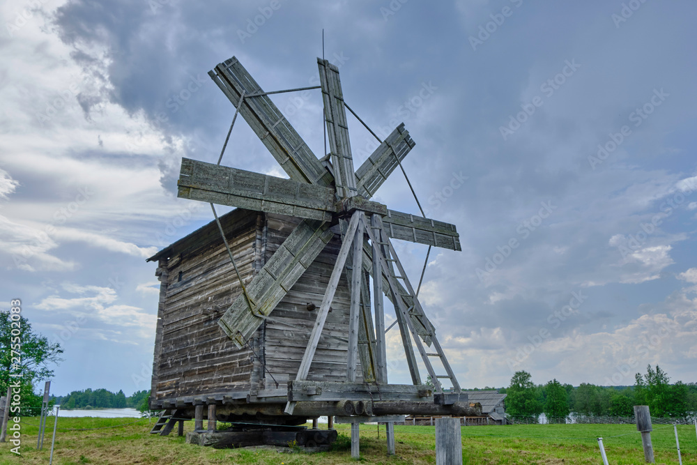 Scenic view of small wooden windmill on Kizhi island on Onezhsky lake in Russian Federation. Beautiful summer sunny look of traditional industrial building of russian North in Karelia