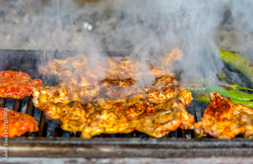 Tasty chicken meat on the grill with fire flames