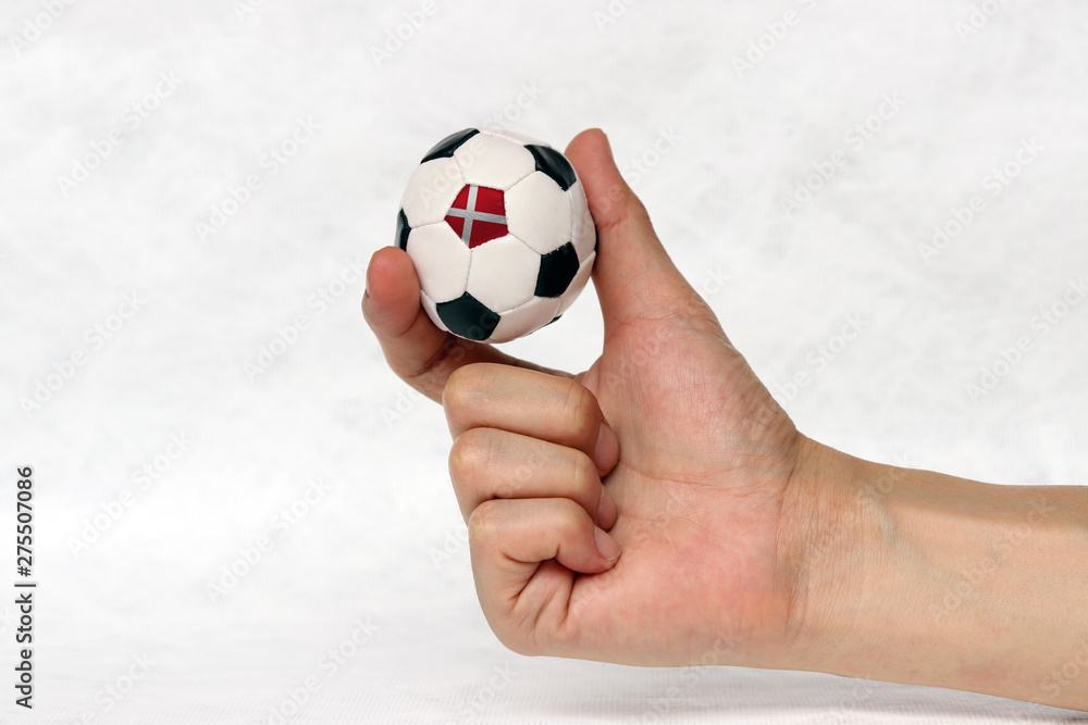 Mini ball of football in hand, hold it with two finger on white background. Concept of sport or the game in handle or minor matter. Mini ball of football in hand, hold it with two finger on white background. Concept of sport or the game in handle or minor matter.