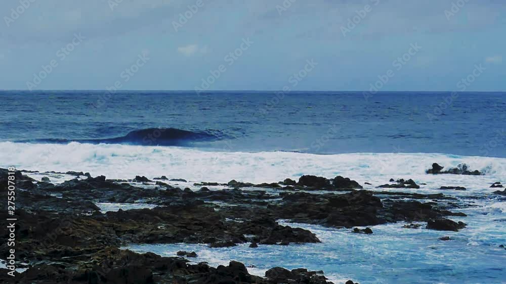 Waves build from a calm bright blue ocean and smash over rocks along the beaches of Tenerife, Canary Islands. Beautiful turquoise water washing over rocks on the beach. Slow motion. Waves build from a calm bright blue ocean and smash over rocks along the beaches of Tenerife, Canary Islands. Beautiful turquoise water washing over rocks on the beach. Slow motion.