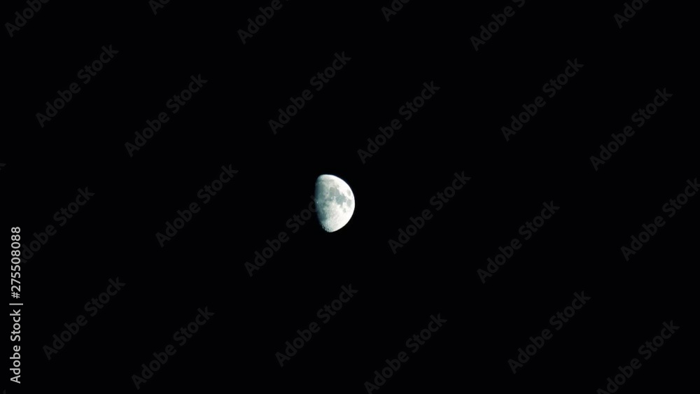 Half moon glowing in a dark night sky. Midnight sky with no stars illuminated by a bright half moon reflecting sunlight. Space and astronomy concept. Half moon glowing in a dark night sky. Midnight sky with no stars illuminated by a bright half moon reflecting sunlight. Space and astronomy concept.