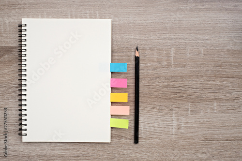 Top view, blank book and pencil on blank book on the wooden table.
