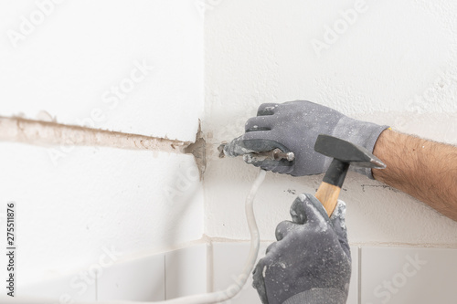 a craftsman punch a slit into a wall photo