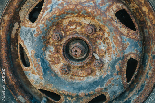 Old and weathered car wheel with damaged rusty rim – Used rubber with small cracks from vehicle tire