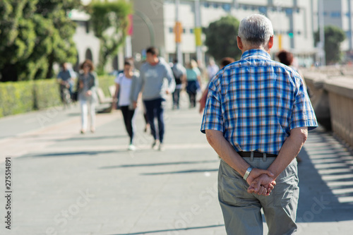 Starszy mężczyzna spaceruje samotnie po mieście