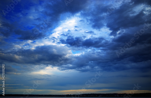Distant land covered by dramatic clouds landscape background